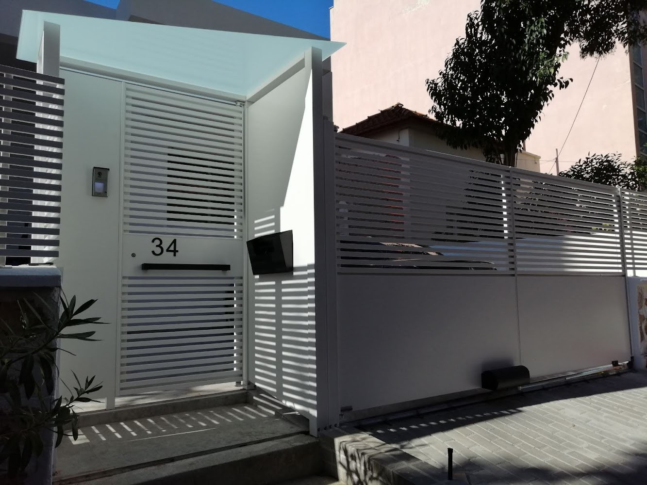 Λευκή συρόμενη μεταλλική πόρτα με περίφραξη — εγκατάσταση TSEVAS TECHNICAL